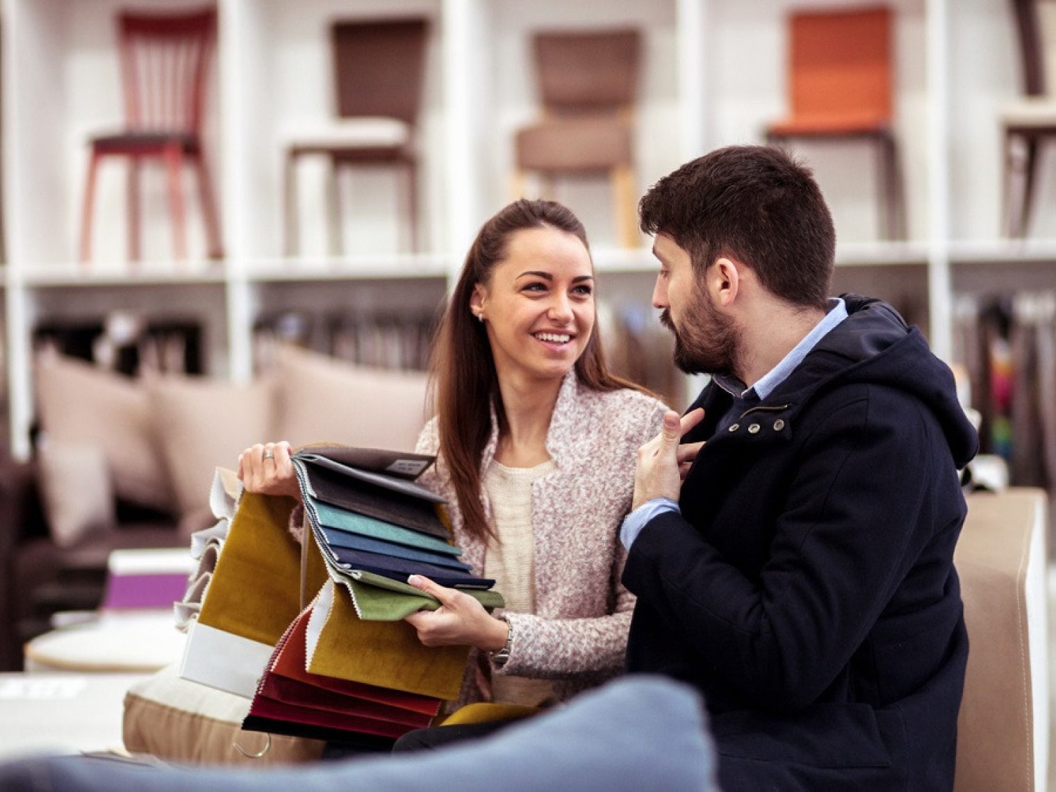 A couple in a store looking at textile swatches.