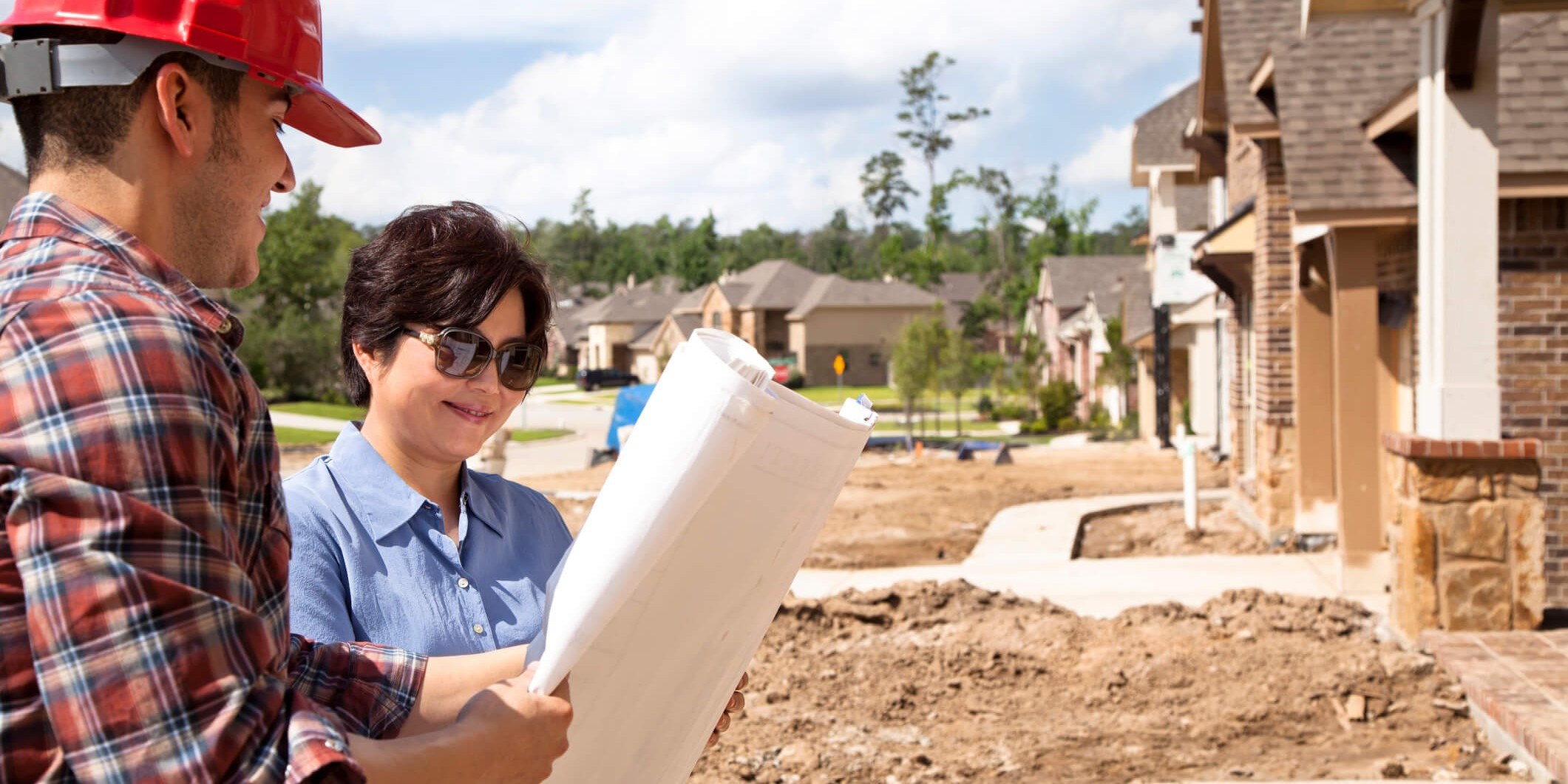 Builder discussing home plans with homebuyer.